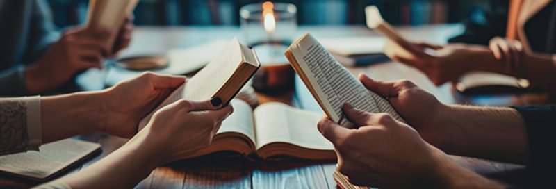 group of hands holding books