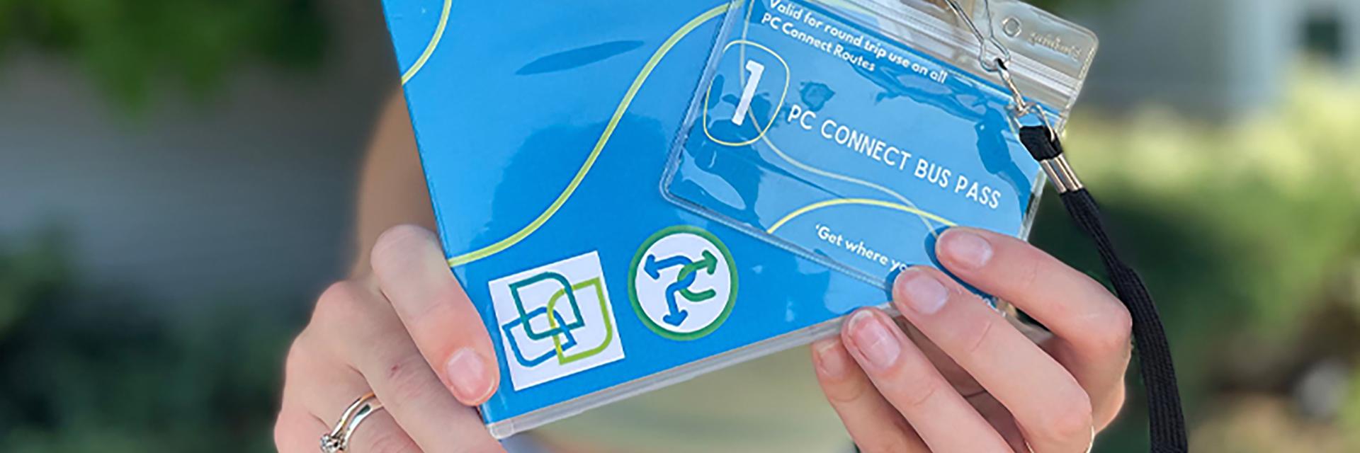 Hands holding a PC Connect Bus Pass
